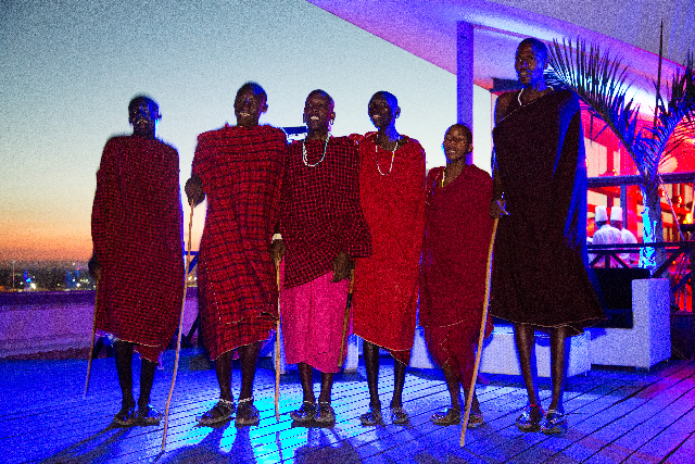 A line of performers holds the night in brilliant color and poised stillness.